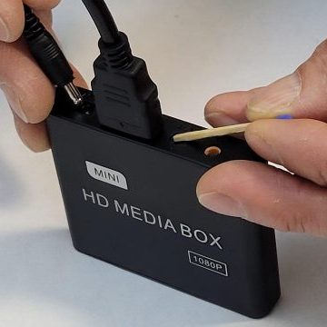 Reset pinhole button on media player near AV/USB ports